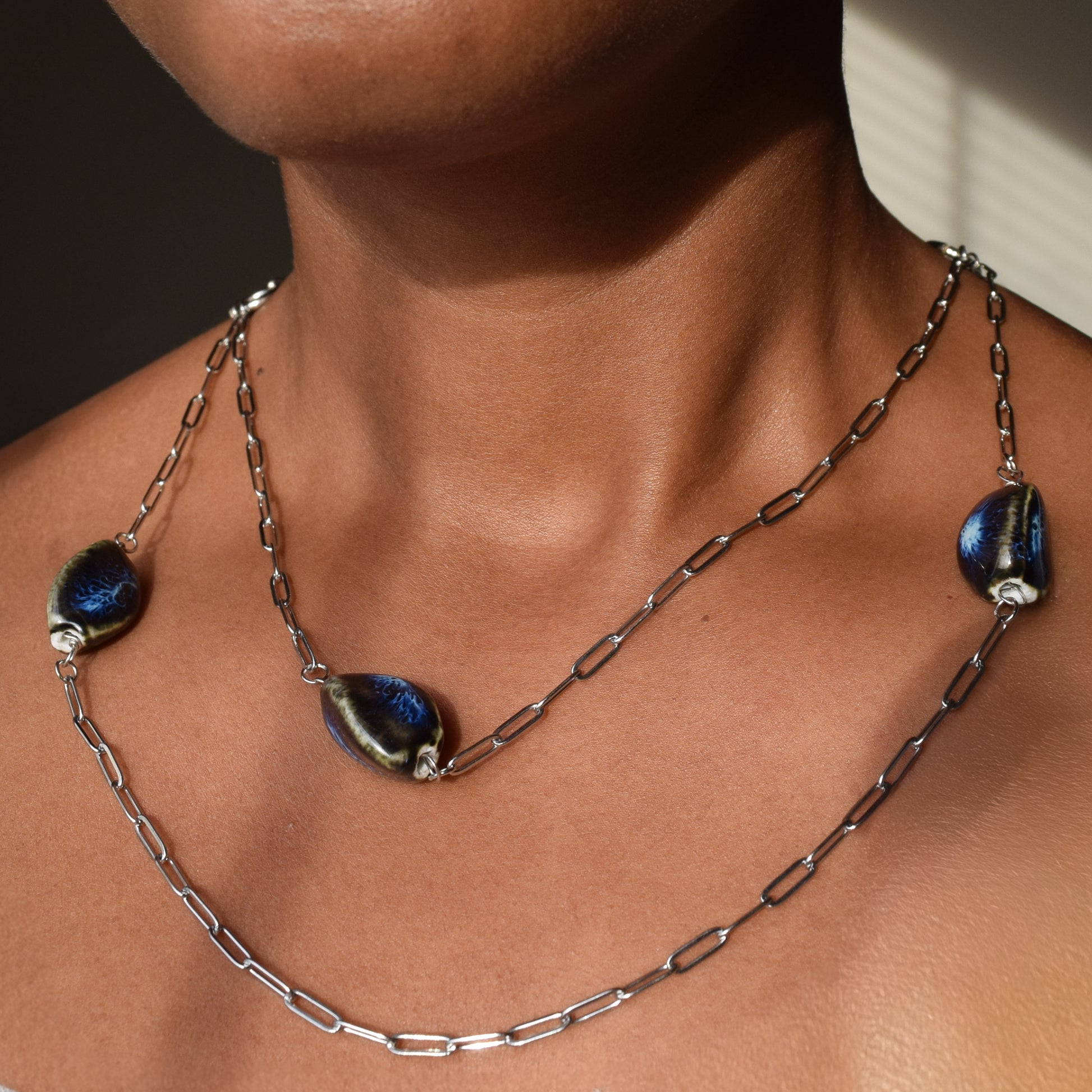 Handcrafted with silver paper-clip chain featuring twisted oval ceramic beads for elegant, refined style by Ayiti Chérie. Haitian-inspired, lifestyle brand