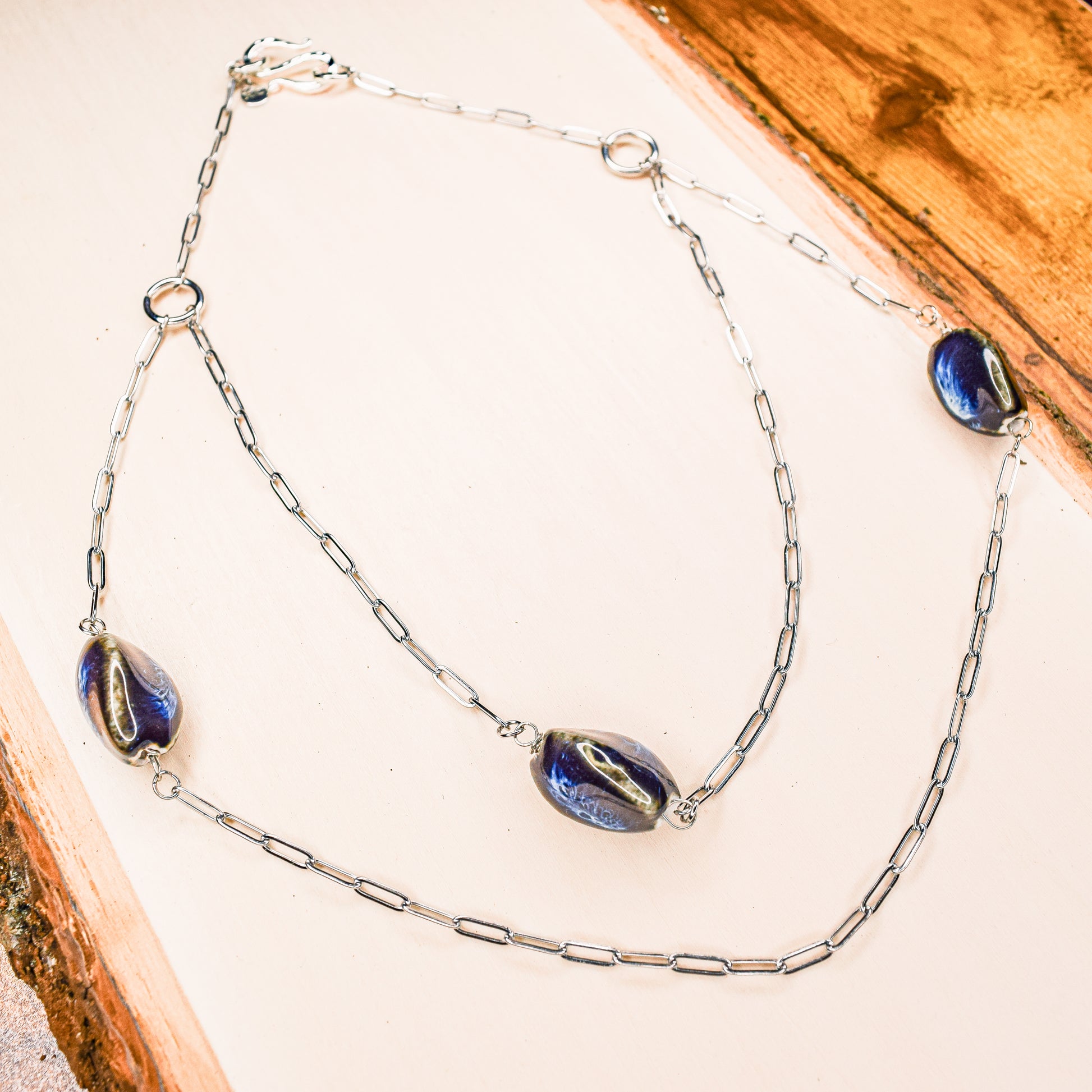 Handcrafted with silver paper-clip chain featuring twisted oval ceramic beads for elegant, refined style by Ayiti Chérie. Haitian-inspired, lifestyle brand