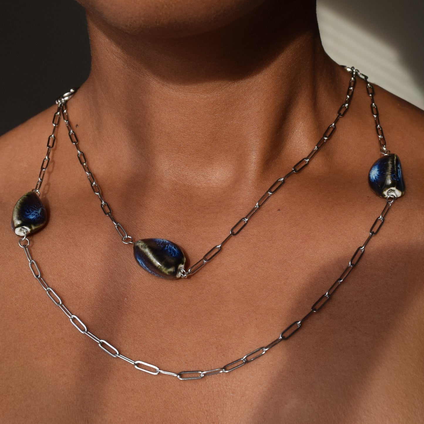 Handcrafted with silver paper-clip chain featuring twisted oval ceramic beads for elegant, refined style by Ayiti Chérie. Haitian-inspired, lifestyle brand